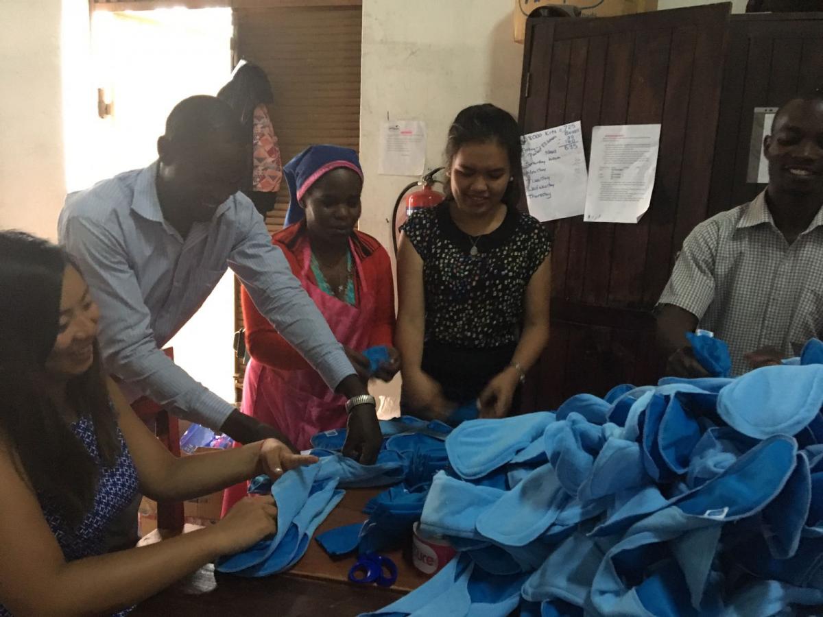 UBC student surveyors helping pack AFRIpads products with staff in 2018 (left to right: Kim Woo, Prince George Oleny, Judith Nassaka, Jeanne Legua, George William Sseruwu) (photo: AFRIpads)