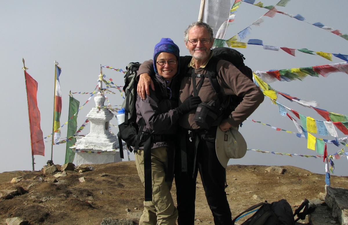 The couple returns from a trek to Langtang Valley, Nepal, next to prayer flags near Gosainkund, in 2010