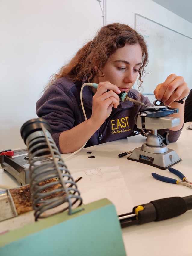 UBC PhD student Geena Little soldering connections for an Arduino micro-controller used in a simple accelerometer to measure ground shaking motion: she and other students build these as part of the 2022 PRODIGY summer school at the Quadra Island Ecological Observatory, run by the Tula Foundation (photo: Philippe Tortell)
