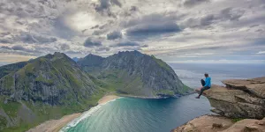 Traveler sitting at the edge of a rock formation (photo: stein egil liland/Pexels)