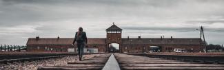Woman on former train tracks at Auschwitz Birkenau Concentration Camp