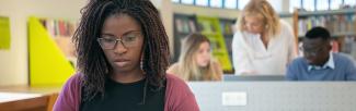 Student working on laptop at library (photo: Kampus Production/Pexels)